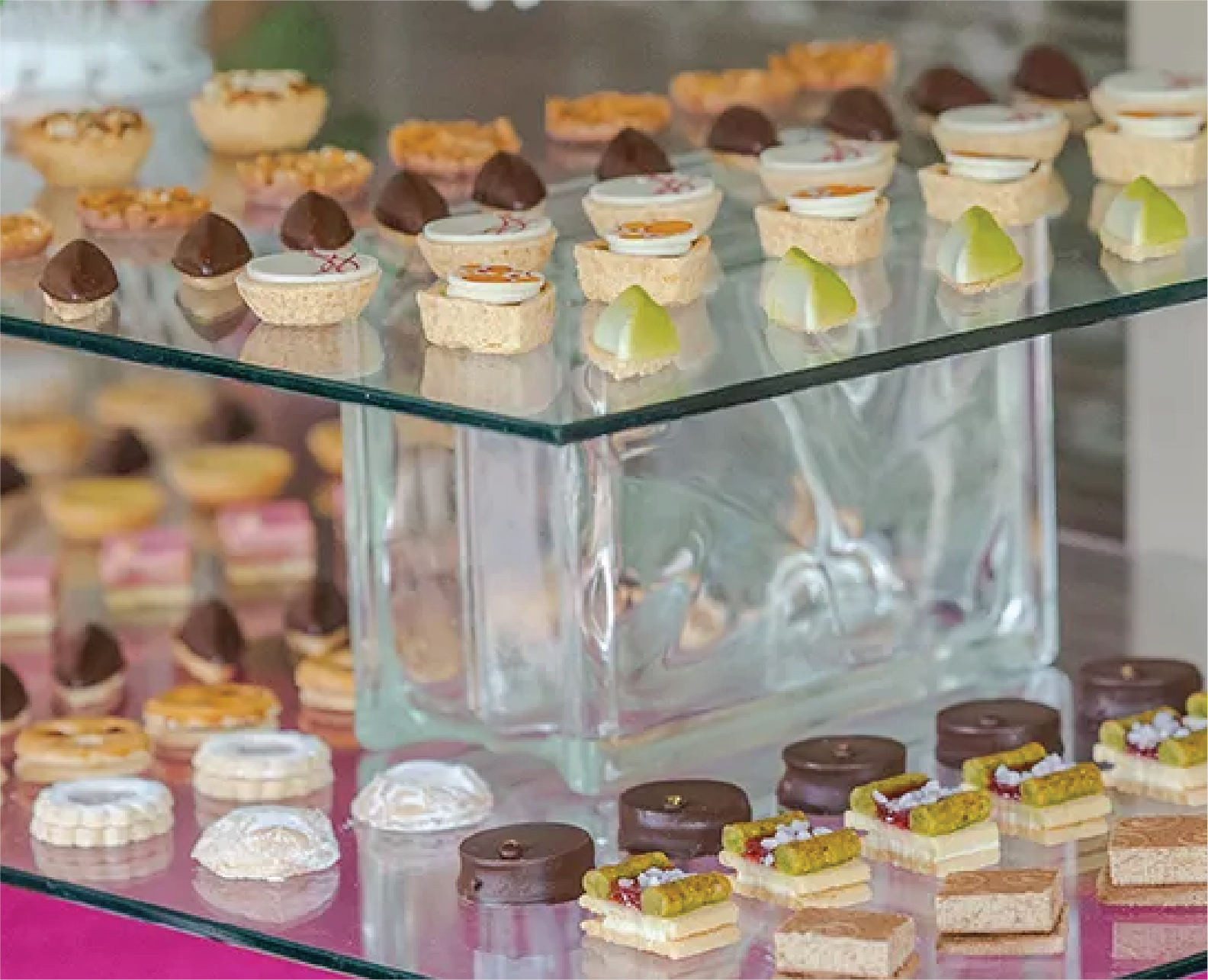 Catered dessert table with miniature cakes and sweets for a corporate function