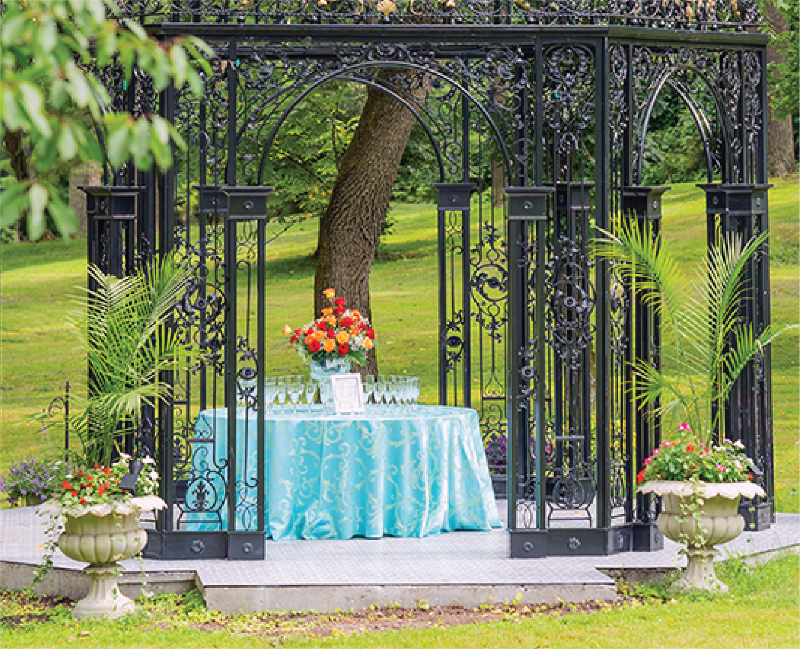 Wedding reception drink station with floral arrangements in a garden setting